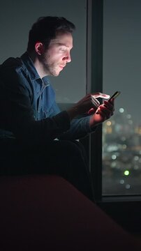 analyzing urgent message by window, night analyst focused on important alert with city glow background