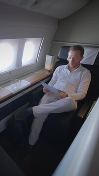 business traveler checks paperwork onboard, elite passenger studies documents during highend flight