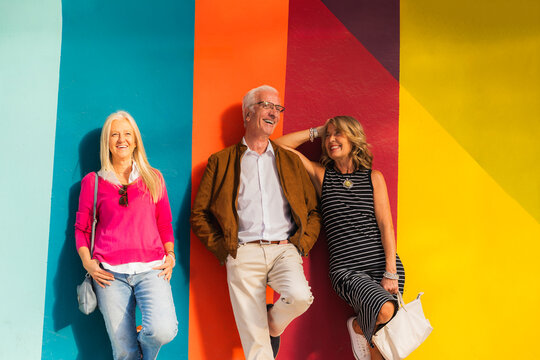 Happy mature friends laughing enjoying urban leisure time