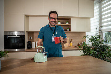 Male healthcare professional enjoying coffee break in kitchen