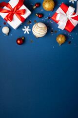 Fototapeta premium Red and white Christmas decorations and gifts on blue background.