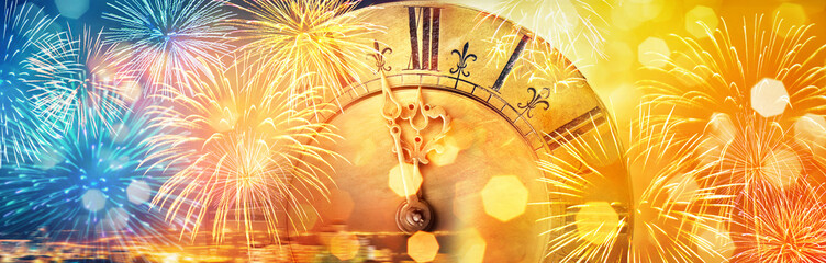 Retro clock close to midnight, fireworks and lights. New Year's and Christmas holiday background.