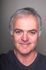 Obraz premium Studio portrait of handsome mature man against grey background.