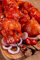 chicken fillet on skewers, marinated in spices, on a wooden chopping board, top view, no people,
