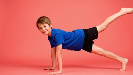 Energetic young boy practicing gymnastics, showcasing strength and balance. A happy kid actively engaged in fitness exercise, promoting health and agility