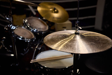 Obraz premium Closeup of shiny percussions, Intimate jazz club setting with textured metal and blurred audience, Glimmering cymbals and drums under warm amber light in cozy jazz venue