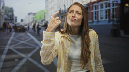 Fototapeta premium Woman shrugging with palms up and open hands on a crowded city street, looking puzzled and uncertain about direction; confusion.