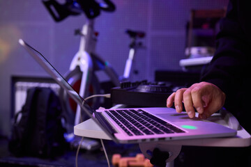 Individual managing broadcast amidst purple lighting and tech equipment, Person programming live...