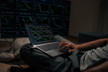 Skilled trader analyzing real-time stock market data and financial charts on laptop, closely monitoring multiple screens with cryptocurrency trends and investment indicators, close-up.