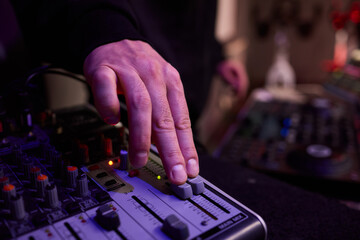 Closeup of tactile controls and vibrant patch cords in studio, Adjusting analog sequencing equipment with bright cables and warm ambient lighting in home studio