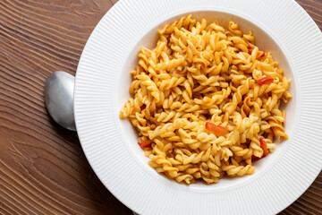 Close-Up of Italian Pasta with Tomatoes and Peppers on a White Plate