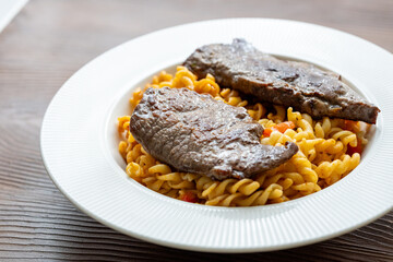 Close-Up of Italian Pasta with Tomato Sauce and Beef Steak