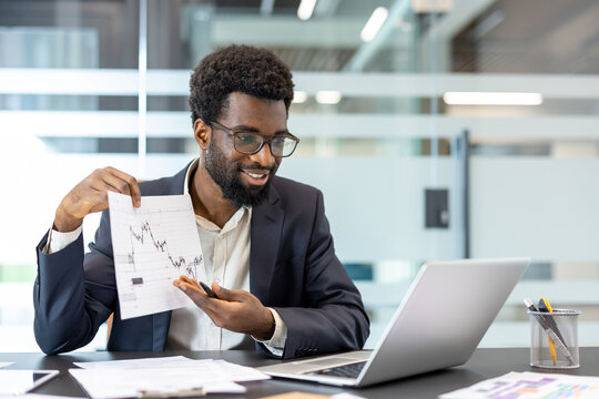Businessman conducting a video conference call from an office, discussing financial data and market trends while presenting a stock chart on a document