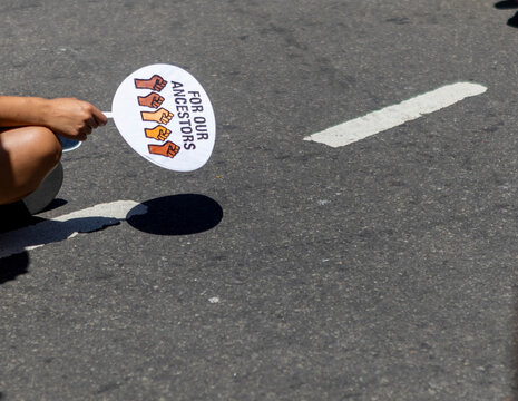 Hand holding protest sign at indigenous rights rally