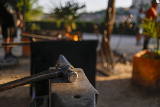Medieval sword forge with hammer on anvil
