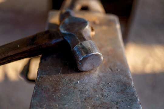 Hammer resting on anvil in medieval sword forge