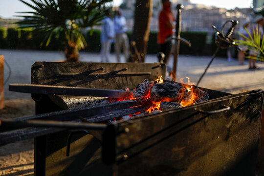 Glowing coals and swords in a medieval outdoor forge