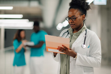 African american doctor checking medical chart in hospital