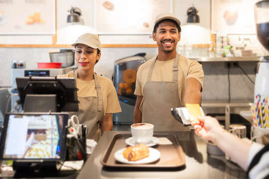 Cafe workers serving customers in a cozy bakery setting