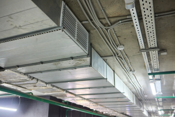 Obraz premium Subterranean parking details, Basement parking area equipped with lighting and plumbing, Underground vehicle shelter featuring electrical wiring and ventilation systems