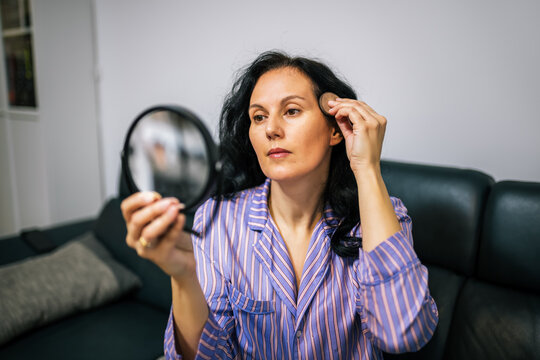 Middle-aged woman covering gray roots with hair powder