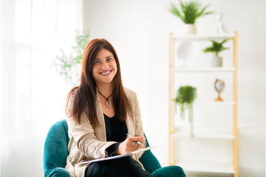 Portrait of woman mental specialist psychologist with clipboard folder on chair