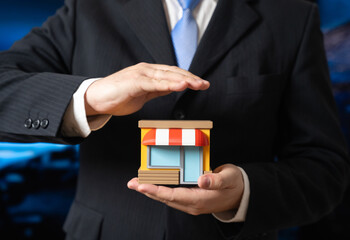 A man protects a store in his hands. Support for small businesses and entrepreneurship. Economic resilience and retail sector stability. SME support programs, economic development and commerce policy.