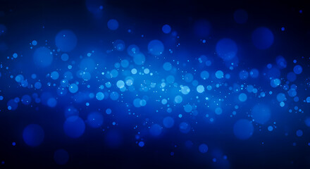 Luminous blue particles creating a beautiful bokeh light effect on a dark abstract background for a festive or digital theme