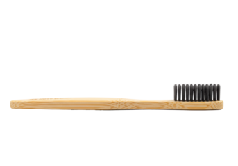 A single ergonomic bamboo toothbrush with dark charcoal bristles on a white background with visible wood grain texture. Zero waste and eco lifestyle concept