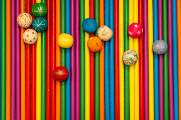 Top view of arranged colorful wooden sticks and painted beads. Abstract rainbow background for crafts or kids