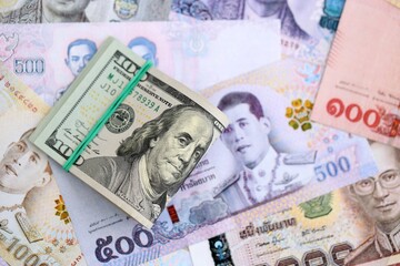 Thai baht currency money bills and bunch of us dollar banknotes close up. The concept of economics and currency exchange