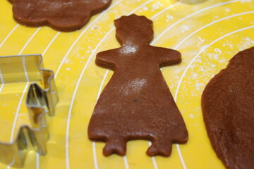 Gingerbread cookie dough shapes prepared for baking during a holiday gathering in a home kitchen