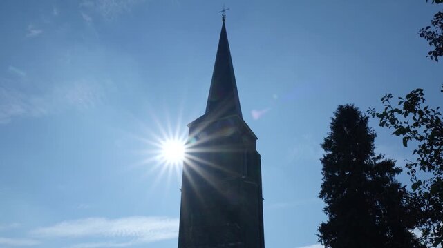 Church steeple silhouette with sun flare