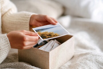 Hands gently hold a photo, organizing memories from a box during a mindful decluttering session