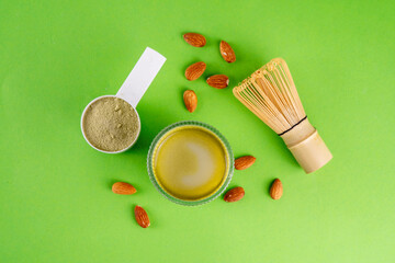 Matcha powder protein drink, vegan matcha tea protein whey shake cocktail, with almond.Healthy vegetarian superfood, trendy diet beverage, with protein powder in scoop, on white green background