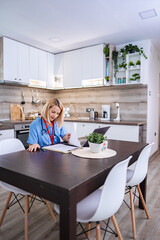 Fototapeta premium Female Doctor Working From Home in her Kitchen