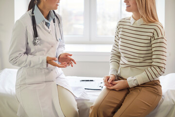 Fototapeta premium Close up shot of a patient engaging in a conversation with a doctor or nurse during a medical consultation at a hospital or clinic. Healthcare, communication, and the delivery of medical services.