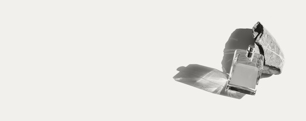 Perfume bottle with blank label on pastel background with natural stone. Fashion and beauty concept. Color of the year 2026 inspired background