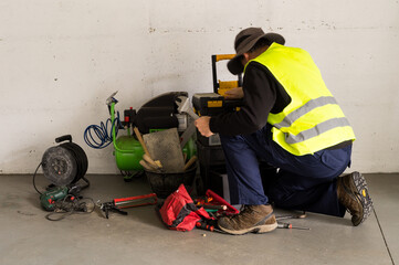 Fototapeta premium Construction Worker Adjusting Equipment with Pipe Wrench