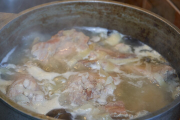 Pieces of meat boil in broth, Preparation of meat broth or soup in a large metal saucepan, the process of heat treatment of meat