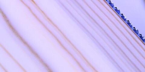 Close-up shot of a wooden surface with visible grain and a saw edge.