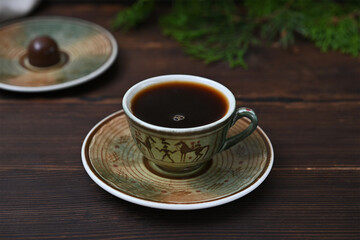 a cup of black coffee on a wooden background
