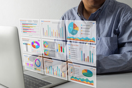 Businessman working on laptop with holographic virtual dashboard displaying financial charts, data analysis graphs, and business statistics, representing fintech and digital marketing concept.