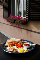 Sunny Outdoor Breakfast Plate With Toast Eggs Sausage Beans Tomatoes And Sauce