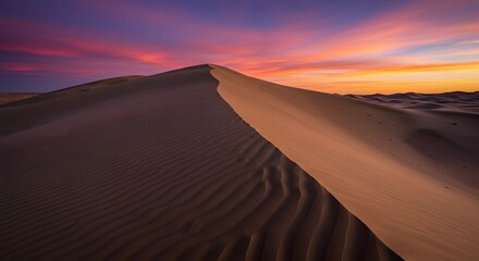 The abstract form of a sand dune against the sky.