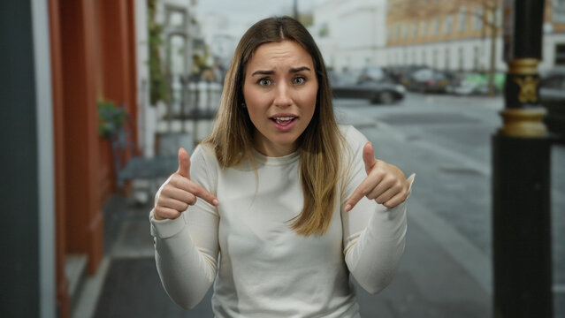 Woman gesturing confusion on city street as cars blur in the background creating an engaging outdoor scene filled with curiosity and expression.