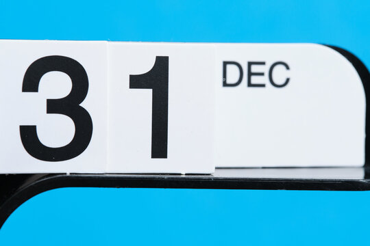 Closeup of a calendar date on a blue background. Date 31 December.