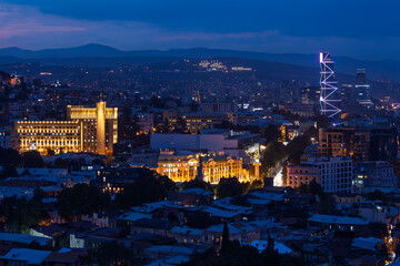 Tbilisi Skyline With Historic Buildings And Illuminated Modern Skyscraper At Night