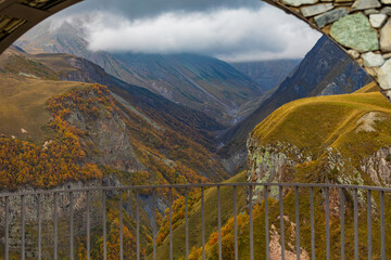 Obraz premium Framed View Of Autumn Mountain Valley Through Stone Arch In Georgia