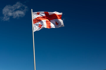 National Flag Of Georgia Waving Against Blue Sky